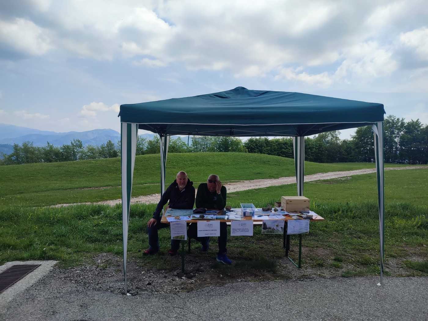 Un paio seduti di uomini sotto un gazebo informativo in Col D'Artent