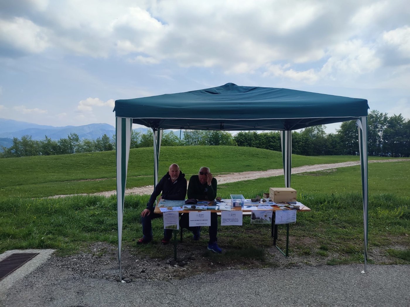 Un paio seduti di uomini sotto un gazebo informativo in Col D'Artent