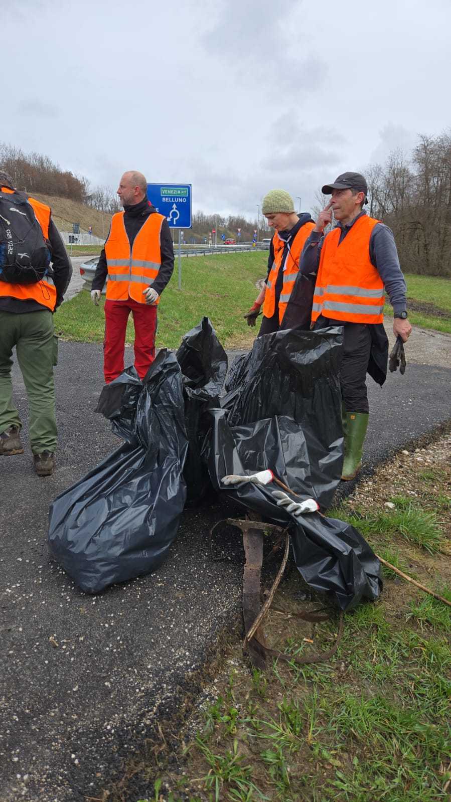 Alcuni volontari con giubbotti arancioni durante una giornata ecologica